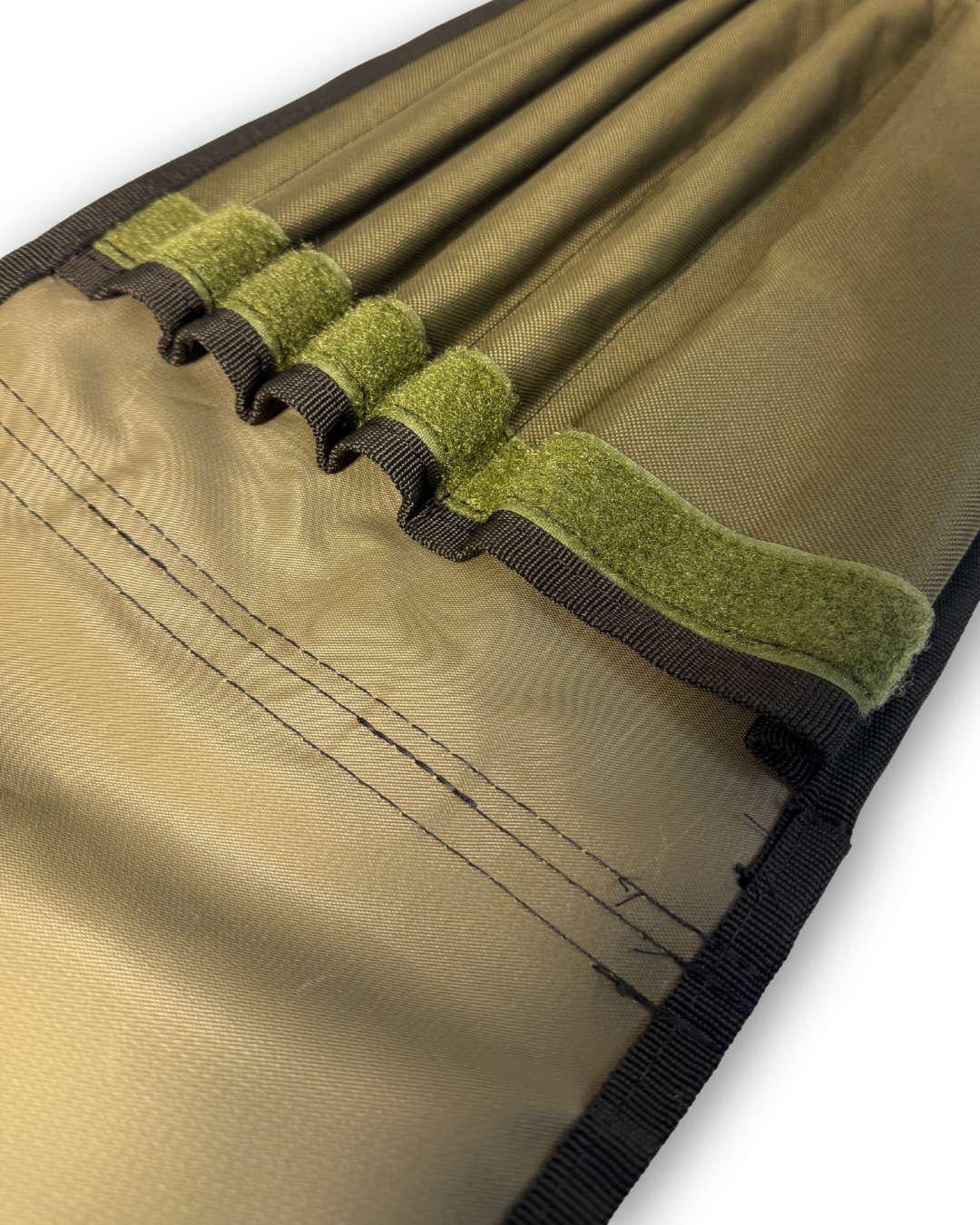 Close up of an open green pouch with sections for bankware. The pouch has black trim and a green hook and loop Velcro strip fastening.